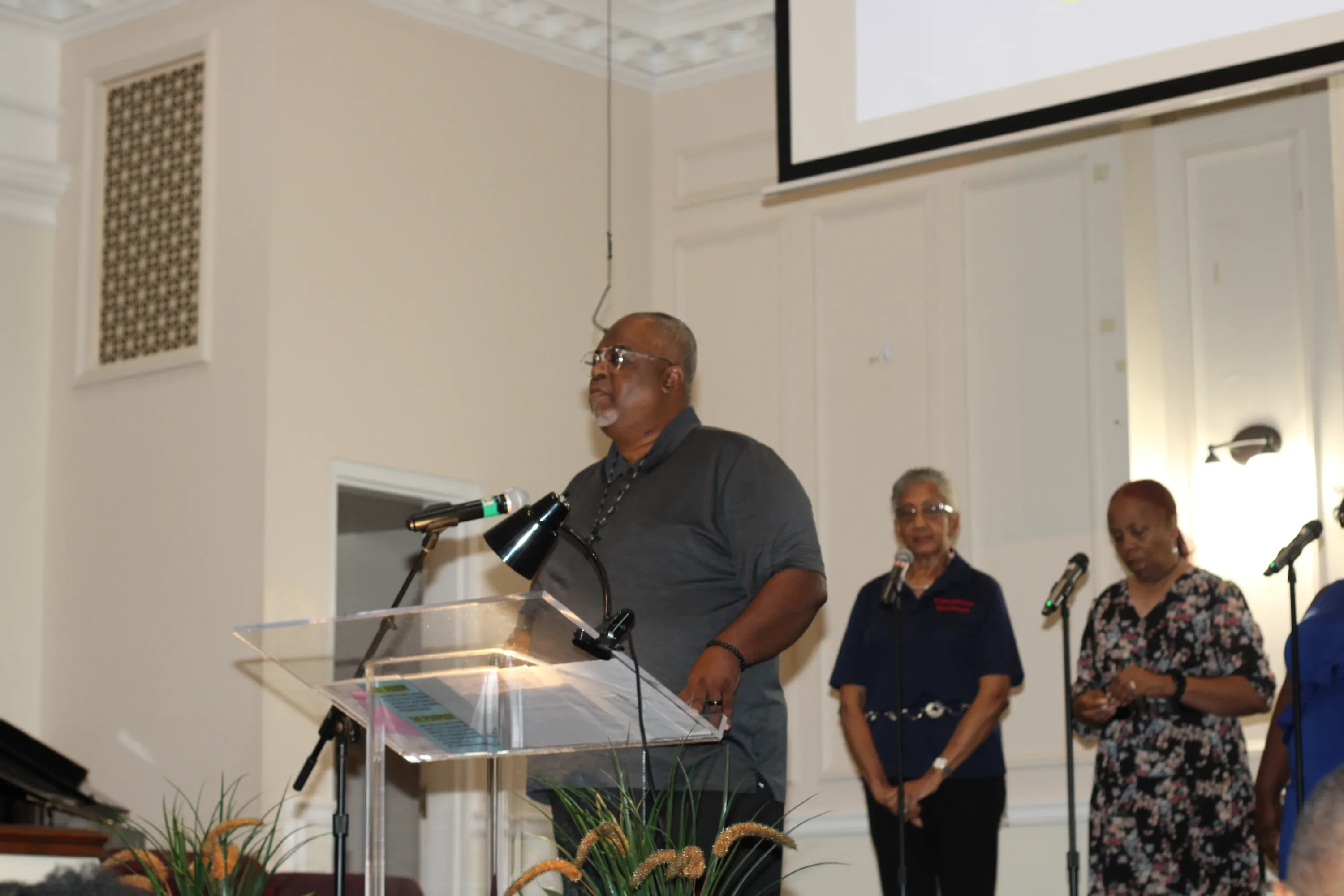 A member speaking from the lectern during a Sunday service